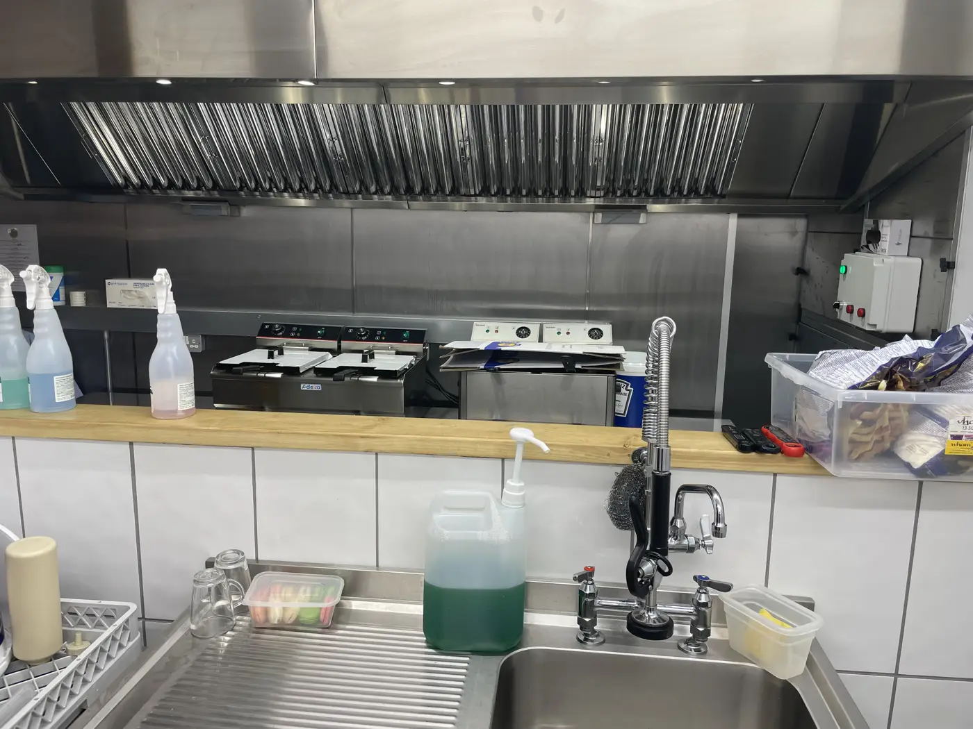 Stainless steel recirculation canopy with baffle filters and control panel above fryers in the pop-up kitchen at Hop Kettle, Gloucester Docks